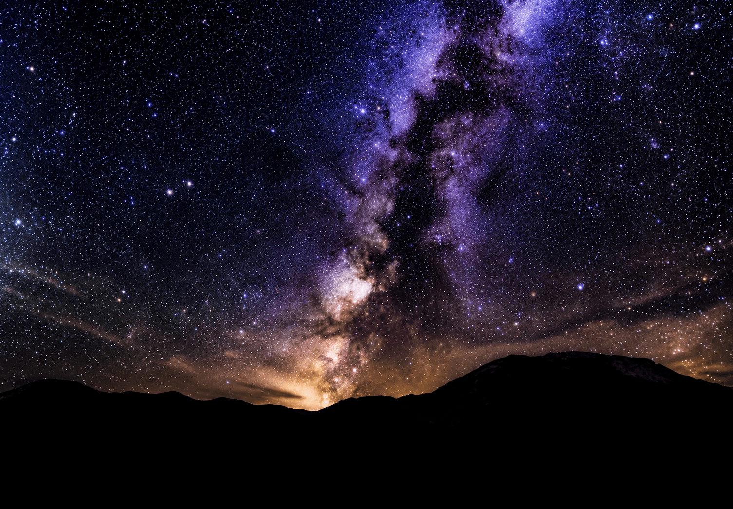Vía láctea sobre la silueta de las montañas